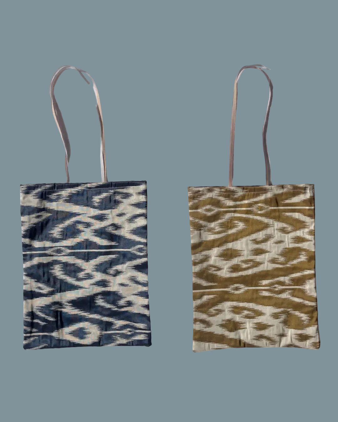 Silk ikat fabric tote bag with long handles. One side has a navy blue and cream ikat pattern, and the right bag has a golden mustard yellow and cream ikat pattern.