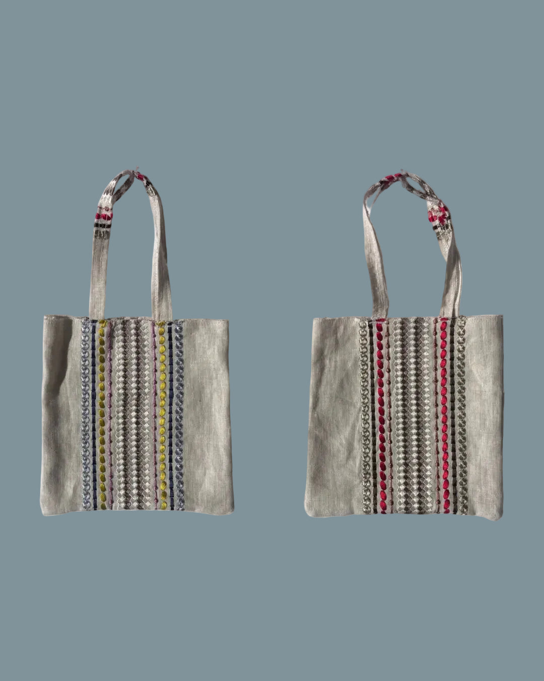 Two views of a small canvas tote bag with embroidered vertical stripes in blue, yellow, red, and silver, featuring cream-colored handles with red and blue bead accents.