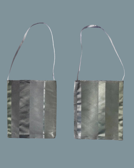 Two views of a small shoulder bag with a metallic silver-gray striped pattern and a thin dark strap.