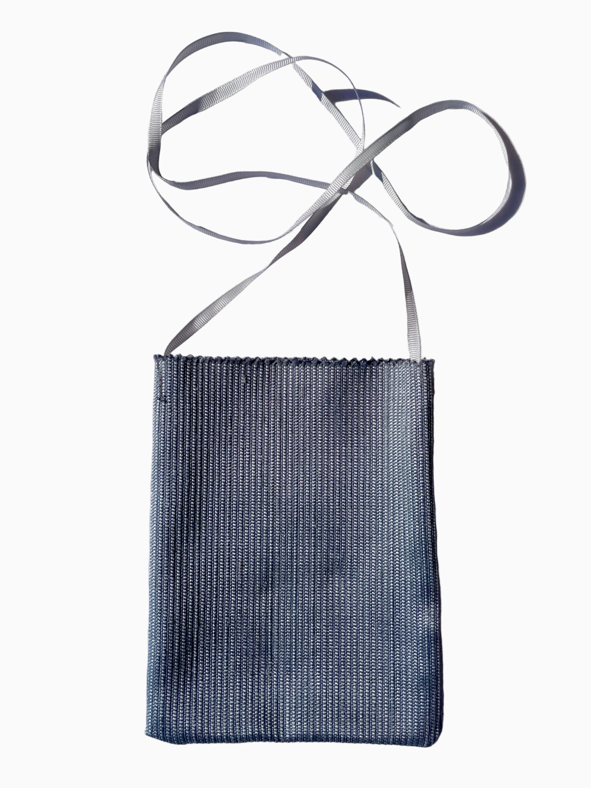 A small rectangular woven fabric pouch in a muted blue-gray color with a thin light gray strap