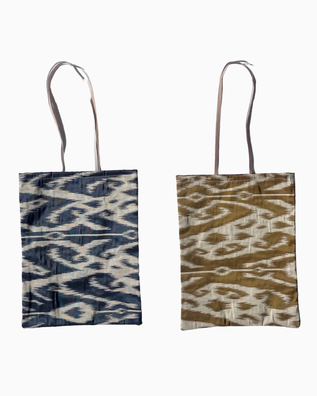 Silk ikat fabric tote bag with long handles. One side has a navy blue and cream ikat pattern, and the right bag has a golden mustard yellow and cream ikat pattern.