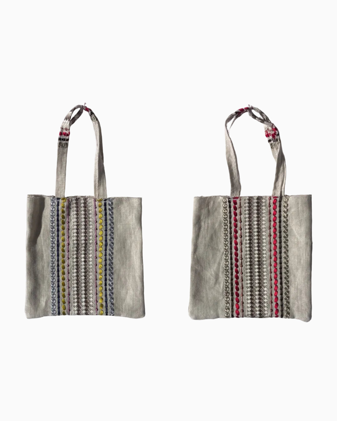 Two views of a small canvas tote bag with embroidered vertical stripes in blue, yellow, red, and silver, featuring cream-colored handles with red and blue bead accents.